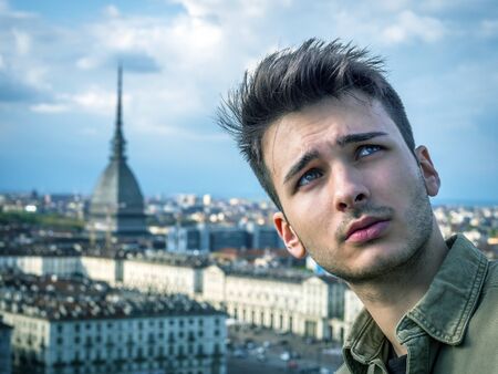 Young ma posing in Turin, Italy with Mole Antonelliana, the symbol of the city