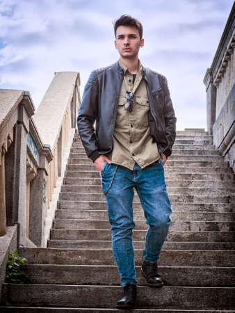 Attractive young man outdoor walking down stone stairs