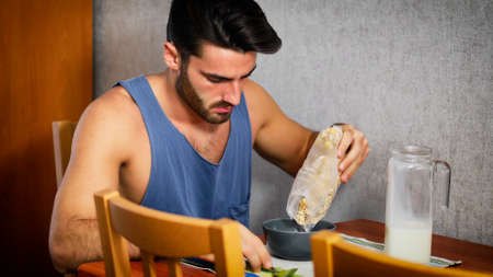 Attractive Young Man Eating Breakfast Sitting at Table