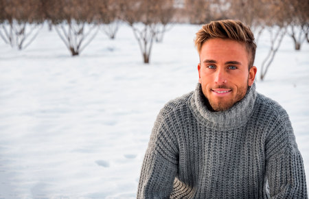 Handsome man in snow posing for cameraの写真素材