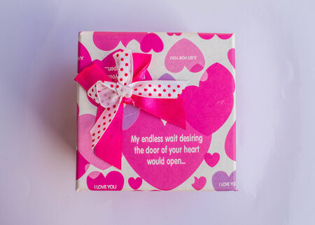 Pink gift box with decorative bow on the floor.の写真素材