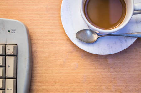 Cup of coffee and keyboards in the officeの写真素材