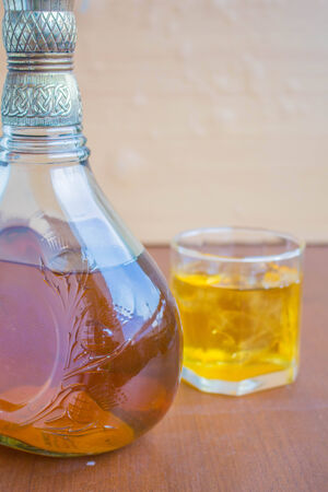 Bottle of whiskey on a wooden tableの写真素材