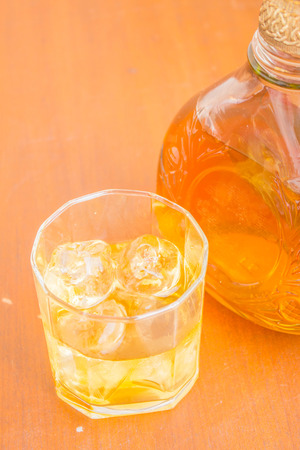 Glass of whiskey with ice on the desktop.の写真素材