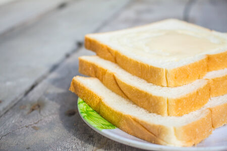 Bread topped with condensed milk on wooden