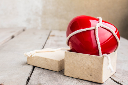 Red Hearts tied with a rope in the box on woodenの写真素材