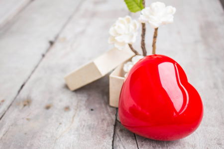 Red hearts and flowers on a wooden tableの写真素材
