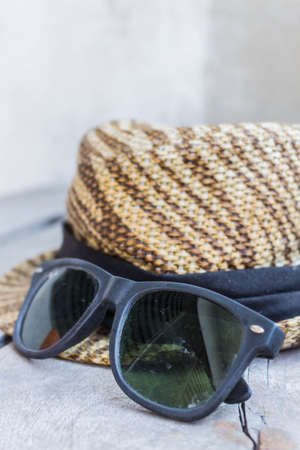 Sunglasses and a hat on a woodenの写真素材