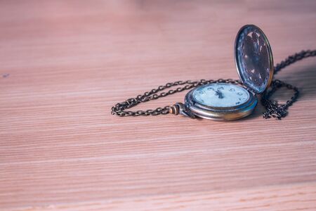 Old clock on a wooden tableの写真素材