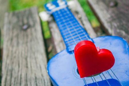 Red heart on a lonely guitar.の写真素材