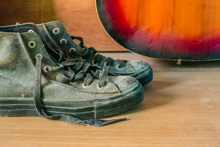Old sneakers on a wooden table with dust.の写真素材
