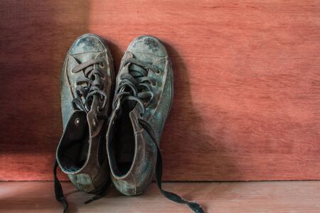 Old sneakers in vintage of wooden wall.の写真素材