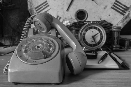Older phones on the desk with a black and white image.の写真素材