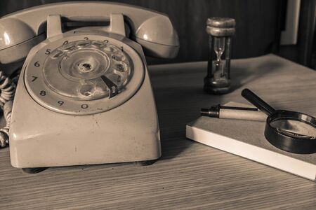 Old phone and stationery on a wooden table.の写真素材