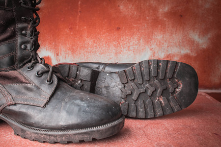 Combat boot on the old wooden table.の写真素材