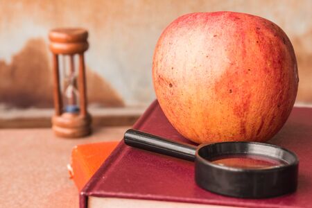 Apple and magnifying glass on a book.の写真素材