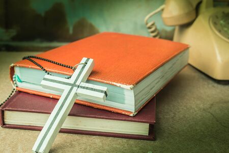 Crosses and old books on a wooden table.の写真素材