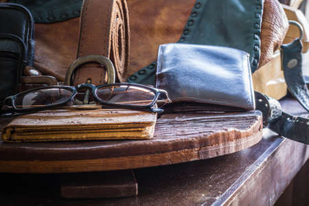 Leather accessories and luggage on a wooden table.の写真素材