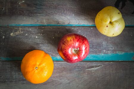 Three types of fruit arranged on a wooden