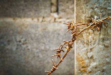 Old barbed wire on a concrete pillarの写真素材