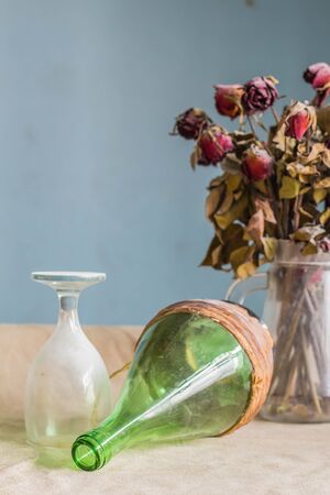 Old wine bottle and glass on the table.の写真素材