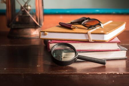 Magnifying glass and working on a wooden table.の写真素材