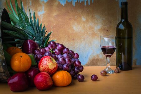 Many fruits and wine bottles on woodenの写真素材