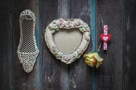 Old picture frame and shoes on wooden background.の写真素材