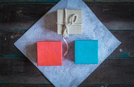 Three white gift boxes on a wooden floor.