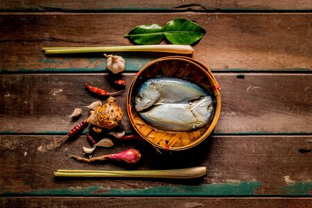 Fish and spices for cooking on a woodの写真素材