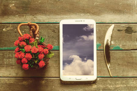 Tablets and flowers on the wooden floor.の写真素材