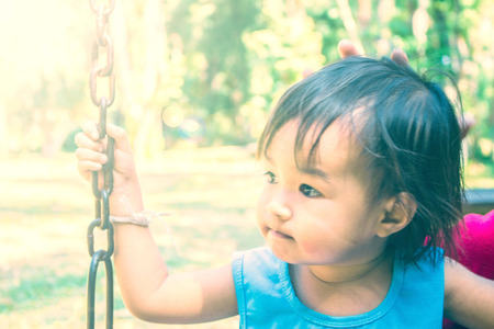 The girls are playing the swings in the park.の写真素材