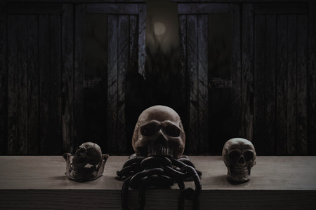 Skulls and chains on old wood with dark at night.の写真素材