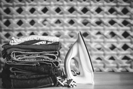 Clothing and iron on a wooden tableの写真素材