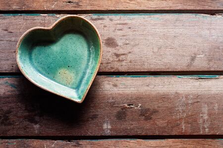 Coffee cup saucer shaped heart on old wood floors.の写真素材