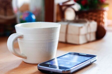 Cup of coffee and gift on the desk.の写真素材
