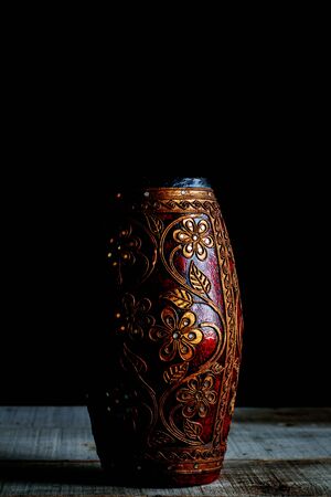 Ancient vase on a wooden floor with a black background.の写真素材
