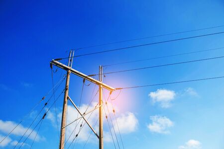 Electricity poles and wires with the blue sky.の写真素材