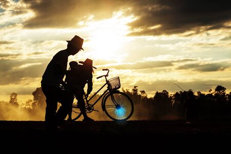 Parents and children living in the countryside at sunset.の写真素材