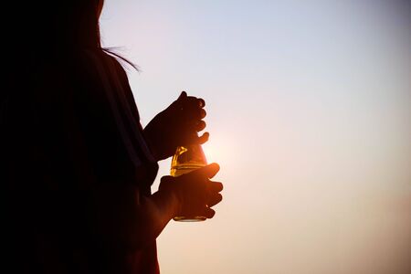 Woman with bottles of drinking water at the sunset.の写真素材