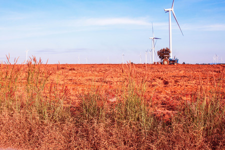 Farmers are using tractors to till the soil for planting cassava with the blue sky.の写真素材