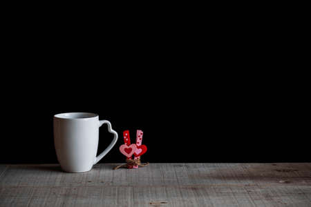 Coffee cups with hearts on the old wood.