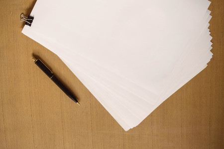 White paper and pen on the wooden table.の写真素材