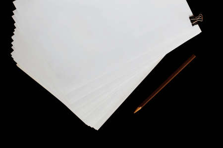 White paper and pencil on a black background.の写真素材