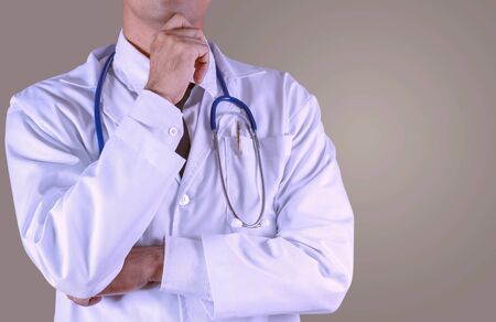 Male doctor with thinking on gray background.の写真素材
