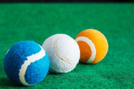 Tennis balls lined up on the grass.の写真素材