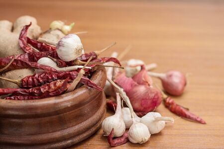 Garlic and dried chilli on a wooden table.の写真素材