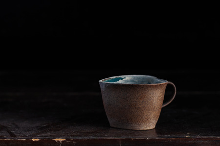 Old ceramic cups and dusty on a  wooden table.