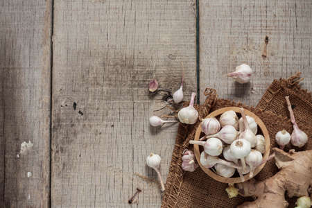Dried garlic in bowls and ginger on old wooden floor.の写真素材