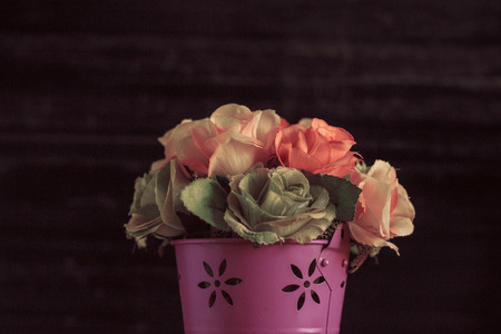 Vase of pink and roses on a black background.の写真素材